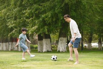 快乐父子在草地上踢足球绿色高端照片