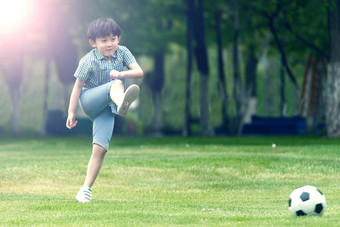 小男孩踢足球彩色图片氛围相片