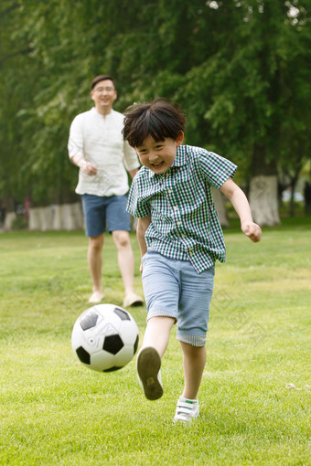快乐<strong>父子</strong>在草地上踢足球保护氛围场景