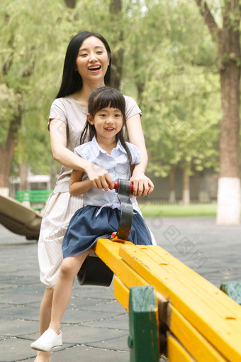 快乐母女玩跷跷板兴奋氛围场景