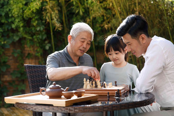 祖孙三代在庭院里下棋