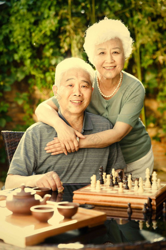 老年夫妇在院子里下棋相伴素材
