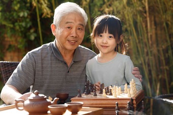 祖父和孙女在庭院里棋子素材