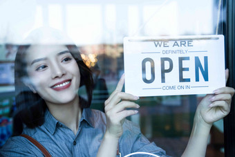 咖啡店的女服务员挂营业标志营业标志高清素材