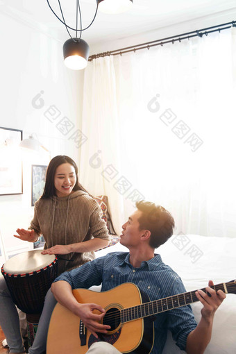 快乐情侣在家演奏乐器彩色图片高端照片