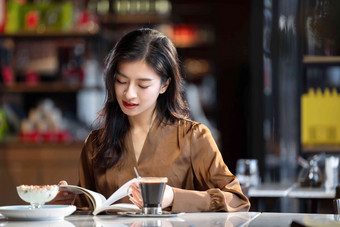 咖啡馆内在看书的青年女人