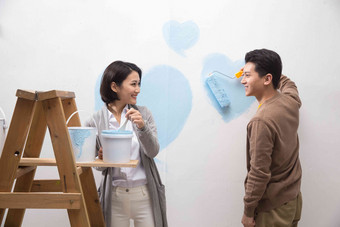 年轻夫妇油漆布置家庭生活