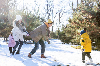 快乐的一家人在雪地里做游戏成年人写实拍摄