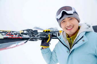 滑雪场上快乐的青年男人扛着滑雪板一个人清晰照片