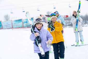 滑雪场内扛着雪具的一家四口中国清晰摄影图