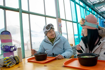 滑雪完的青年伴侣在餐厅用餐户内清晰相片