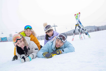 幸福的一家四口趴在雪地上