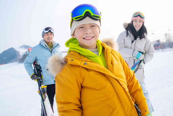 雪场上<strong>拿着</strong>滑雪板的一家三口青年人氛围图片