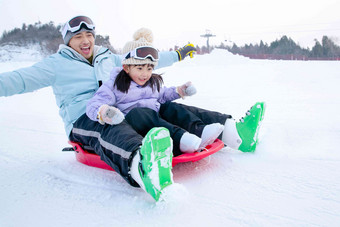 滑雪场上快乐父女坐着雪上滑板滑雪成年人高清影相