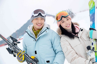 滑雪场快乐的青年伴侣拿着雪具