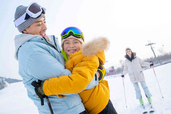 滑雪场上抱在一起的父子和滑雪的母亲东方人高清镜头