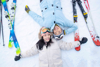 快乐的青年伴侣躺在雪地上