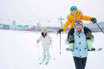 滑雪场内一边滑雪一边玩耍的三口之家人清晰照片