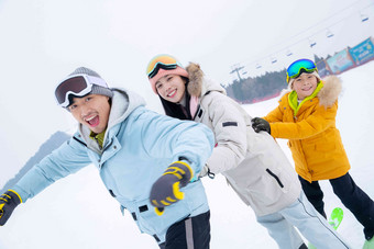 滑雪场上拽着一起滑雪的一家三口面部表情高质量拍摄