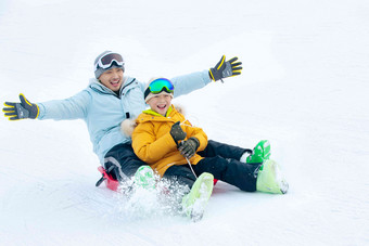 快乐父子坐着雪上滑板滑雪东方人清晰图片