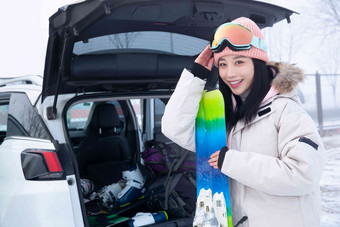 青年女人从后备箱拿滑雪板扶高端图片