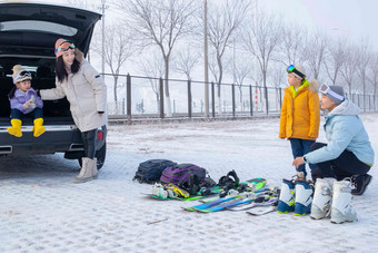 停车场内清点滑雪装备的一家四口女儿高清素材