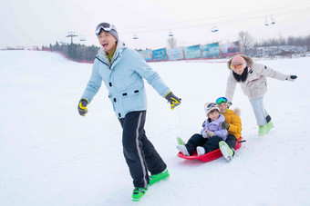 玩雪上滑板幸福的一家四口