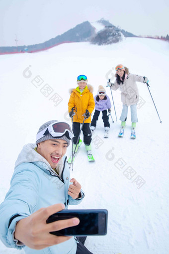 滑雪场上用手机自拍的一家四口中国人场景