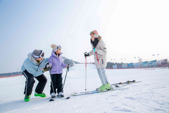 快乐的一家三口在滑雪场玩耍