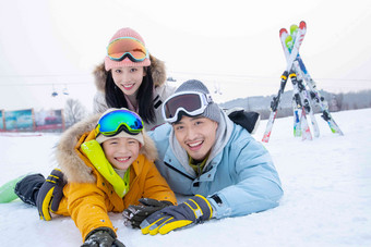 幸福的一家三口趴在雪地上