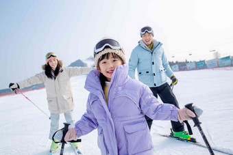 快乐的一家三口在滑雪户外高清素材