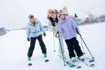 快乐的一家三口在滑雪场滑雪青年女人高清相片