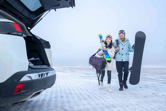 停车场上青年伴侣拿着滑雪板雪高质量摄影图