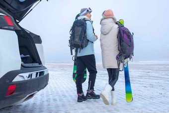 青年伴侣拿着滑雪板的背影男人清晰照片
