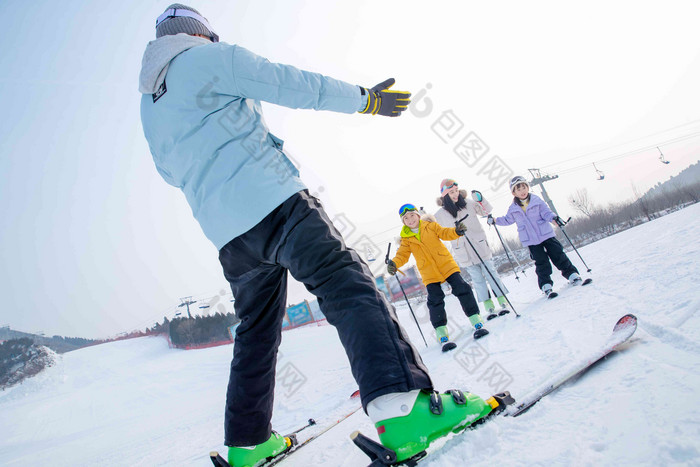 滑雪场内快乐滑雪的一家四口滑雪杖高质量摄影图