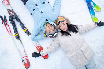 快乐的青年伴侣躺在雪地上中国人场景