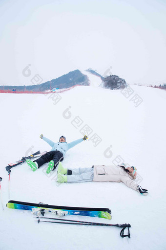 青年伴侣放松的躺在雪地上山清晰拍摄