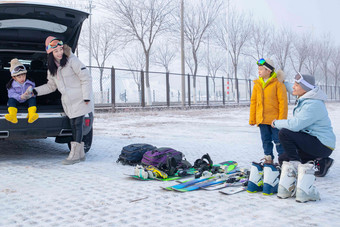 停车场内清点滑雪装备的一家四口蹲相片