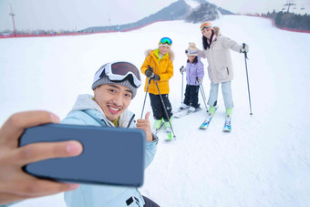 滑雪场上用手机自拍的一家四口郊区高清图片