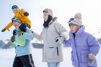 滑雪场上步行的四口之家青年人写实照片