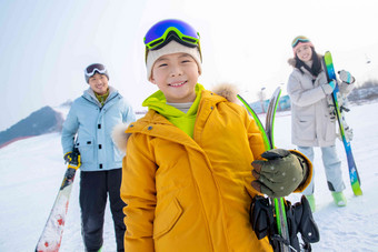 雪场上拿着滑雪板的一家三口男孩<strong>高清图片</strong>