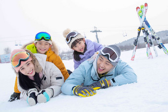 幸福快乐的一家四口趴在雪地上