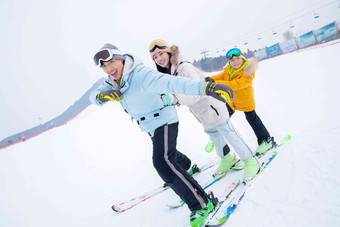 滑雪场上踩着滑雪板排队行走的一家三口户外高质量相片