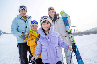 快乐的年轻家庭来滑雪场滑雪玩耍