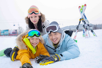 幸福快乐的一家三口趴在雪地上