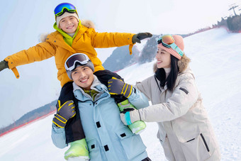 来滑雪场度假的快乐三口之家儿子相片