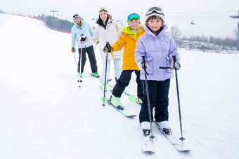 <strong>滑雪场</strong>内站一排滑雪的快乐家庭拿着写实摄影