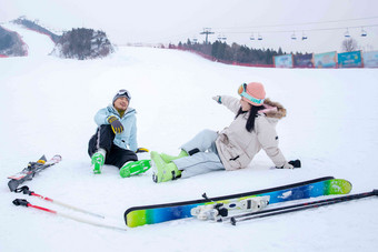 快乐的青年伴侣坐在雪地上闲聊度假高清镜头