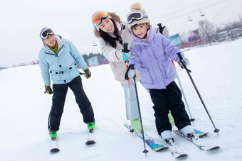 滑雪场上教女儿滑雪的一家三口季节拍摄