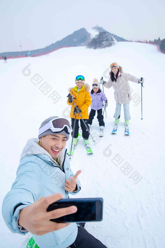 滑雪场上用手机自拍的一家四口冬天写实拍摄